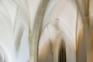 Galerie Ahlemann zeigt ein abstraktes Foto von Ingrid Pohl aus der Konzeptreihe "Zwischen Zeiten" auf dem in hellen Farben ein Teil eines Kirchengewölbes zu sehen ist.