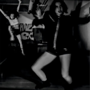 Galerie Ahlemann zeigt ein abstraktes schwarz-weiß Foto von Mick Schäfer aus der Reihe "feminin move" auf dem eine tanzende Frau im Vordergrund und eine hochspringende Frau im linken Hintergrund in einem Kellerraum mit Graffiti an der hinteren Wand zu sehen sind.