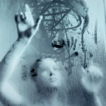 Galerie Ahlemann zeigt ein abstraktes schwarz-weiß Foto von Mick Schäfer aus der Reihe "feminin move" auf dem der Kopf und die Arme einer Frau zu sehen sind, die hinter einer beschlagenen Scheibe, auf die sie Bewegungslinien der Choreografie mit ihren Fingern malt.