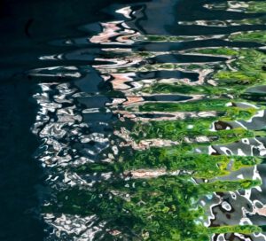 Galerie Ahlemann zeigt ein abstraktes Foto des Fotokünstlers Mick Schäfer aus der Serie "Reflecting Venice" auf dem Wasserreflektionen in überwiegend blauen und grünen Farbtönen zu sehen sind.