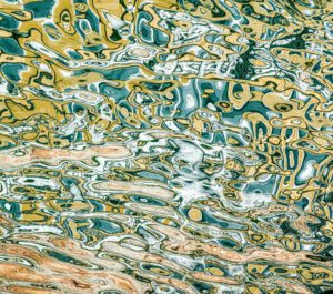 Galerie Ahlemann zeigt ein abstraktes Foto des Fotokünstlers Mick Schäfer aus der Serie "Reflecting Venice" auf dem Wasserreflektionen in überwiegend gelben, blauen und braunen Farbtönen zu sehen sind.
