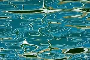 Galerie Ahlemann zeigt ein abstraktes Foto des Fotokünstlers Mick Schäfer aus der Serie "Reflecting Venice" auf dem Wasserreflektionen in überwiegend blauen, weißen und schwarzen Farbtönen zu sehen sind.