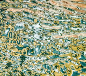 Galerie Ahlemann zeigt ein abstraktes Foto des Fotokünstlers Mick Schäfer aus der Serie "Reflecting Venice" auf dem Wasserreflektionen in überwiegend gelben, blauen und weißen Farbtönen zu sehen sind.