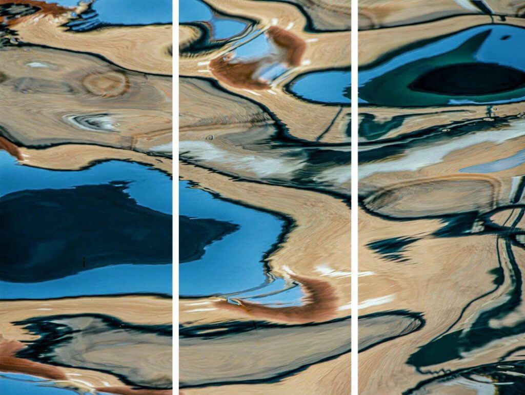 Galerie Ahlemann zeigt ein abstraktes Foto des Fotokünstlers Mick Schäfer aus der Serie "Reflecting Venice", auf dem Wasserreflektionen in überwiegend braunen und blauen Farbtönen zu sehen sind, als Triptychon.