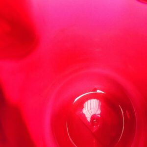Galerie Ahlemann zeigt ein abstraktes Foto der Künstlerin Suria Kassimi aus ihrer Serie "Vas Mirabile", auf dem ein abstrahierter Ausschnitt eines roten Gefäßes zu sehen ist.